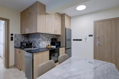 a kitchen with wooden cabinets and a counter top at 75 Prokymea- Steps from the Sea, Downtown, Balcony in Limassol