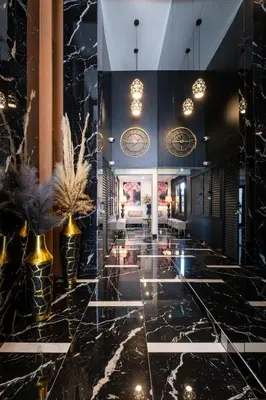 a lobby with black marble and gold vases at Lazuli Hermes Apartments in Larnaka