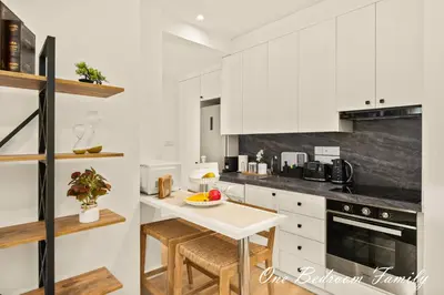 a kitchen with white cabinets and a white table at Lazuli Hermes Apartments in Larnaka