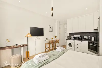 a white kitchen with a large bed in a room at Lazuli Hermes Apartments in Larnaka
