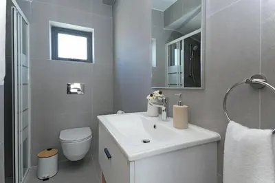a bathroom with a white sink and a toilet at Villa Clio - 3bed All En-suite with Private Pool in Paralimni