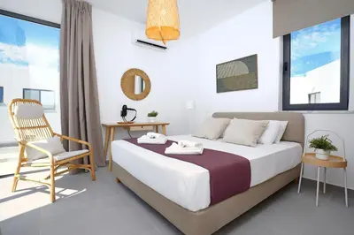 a bedroom with a bed and a chair and a window at Villa Clio - 3bed All En-suite with Private Pool in Paralimni