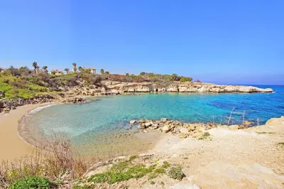 a beach with blue water and a rocky island at Villa Clio - 3bed All En-suite with Private Pool in Paralimni