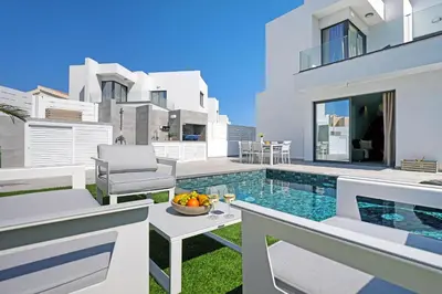 a villa with a swimming pool and a table with a bowl of fruit at Villa Clio - 3bed All En-suite with Private Pool in Paralimni