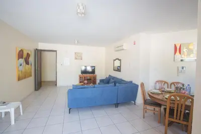 a living room with a blue couch and a table at Napiana Apartments in Ayia Napa