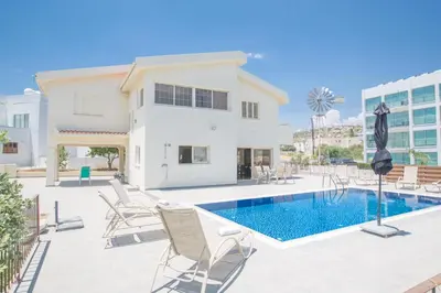 a villa with a swimming pool and chairs at Delfini Villas in Protaras