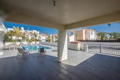 a view of the pool from the balcony of a house at Delfini Villas in Protaras