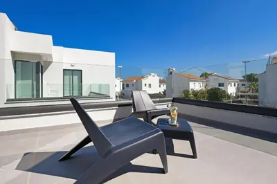 a patio with two chairs and a table on a roof at Villa Flora - 3Bed all En-suite with Private Pool in Paralimni