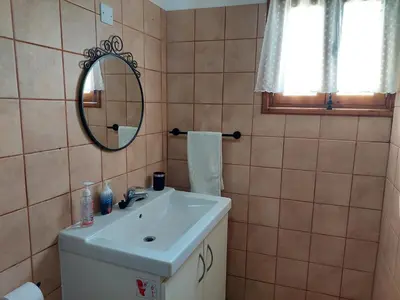 a bathroom with a sink and a mirror at The Little House in Ayios Theodhoros
