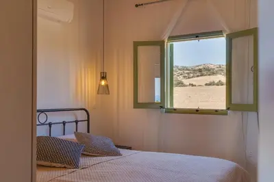 a bedroom with a bed and a window with a view at Eleonas Seaview Cottages in Alaminos