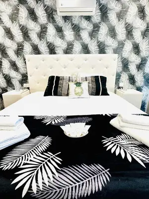 a bedroom with a white bed and a black and white wallpaper at Luxury Villa LAPIS LAZULI in Meneou