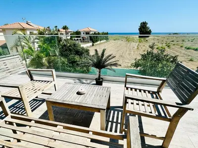 a patio with two chairs and a wooden table at Luxury Villa LAPIS LAZULI in Meneou