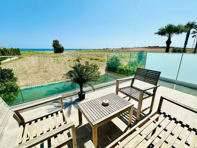 a patio with two chairs and a table on a balcony at Luxury Villa LAPIS LAZULI in Meneou