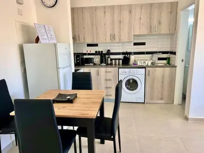 a kitchen with a table and a refrigerator and a washing machine at Cristiana Sea Breeze, Sleeps 3, Free Wifi in Limassol