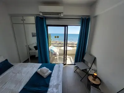 a bedroom with a bed and a view of the ocean at JUST on the beach Makenzy Studio in Scala