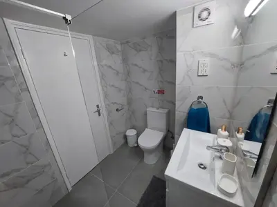 a white bathroom with a toilet and a sink at JUST on the beach Makenzy Studio in Scala