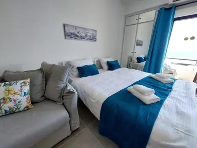 a bedroom with two beds and a couch at JUST on the beach Makenzy Studio in Scala