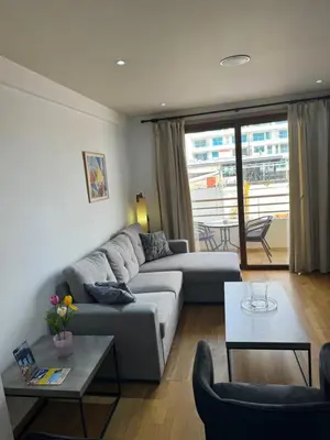 a living room with a couch and a table at Ithaki Phinikoudes Apartment No. 105 in Larnaka