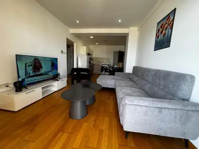 a living room with a couch and a tv and a table at Ithaki Phinikoudes Apartment No. 202 in Larnaka