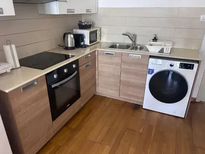 a kitchen with a washing machine and a sink at Ithaki Phinikoudes Apartment No. 202 in Larnaka