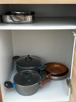 three pots and pans sitting on a shelf in a kitchen at Ithaki Phinikoudes Apartment No. 202 in Larnaka