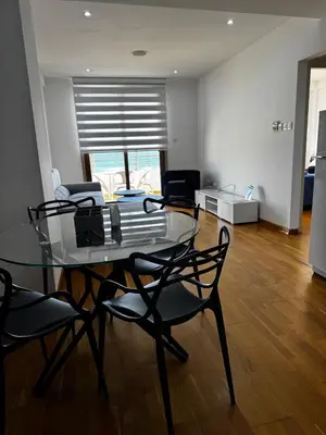 a dining room with a glass table and chairs at Ithaki Phinikoudes Apartment No. 202 in Larnaka