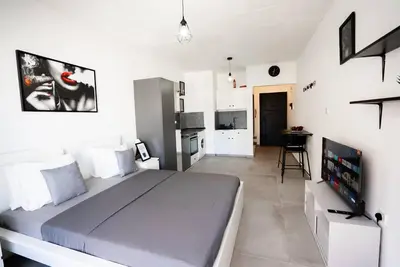 a bedroom with a large bed and a television at Hubstay - Klea's Downtown City Apartment Suite in Larnaka