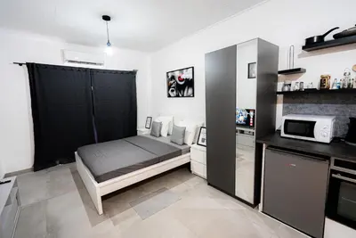 a small bedroom with a bed and a microwave at Hubstay - Klea's Downtown City Apartment Suite in Larnaka