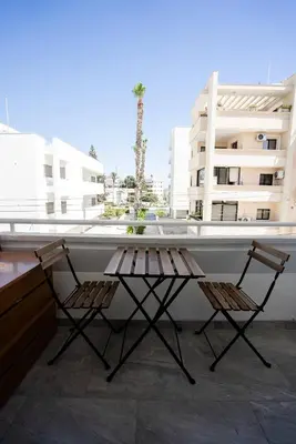 two chairs and a table on a balcony at Hubstay - Klea's Downtown City Apartment Suite in Larnaka
