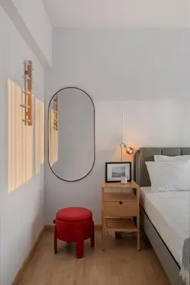 a bedroom with a bed and a red stool and a mirror at Amazing Sea View and Location in Scala