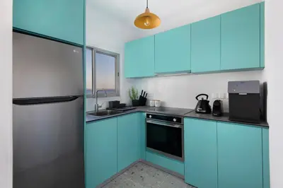 a kitchen with blue cabinets and a refrigerator at Amazing Sea View and Location in Scala