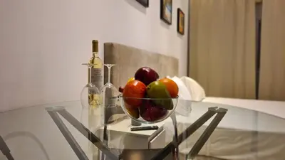a bowl of fruit and a bottle of wine on a glass table at STAY Napa Velvet Apartment in Ayia Napa