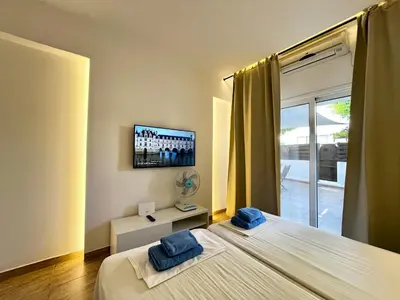 a bedroom with two beds and a tv on the wall at STAY Napa Velvet Apartment in Ayia Napa