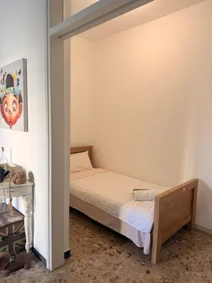 a small bedroom with a bed and a desk at Green Door 3bdr flat City Centre in Nicosia