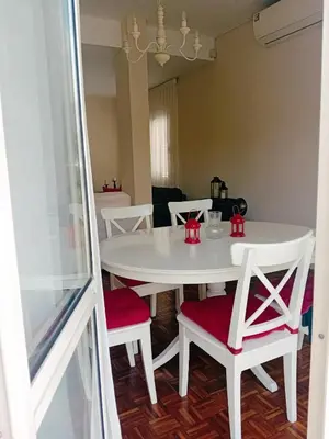 a white dining room table with red chairs and a white table at Green Door 3bdr flat City Centre in Nicosia