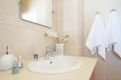 a bathroom with a sink and a mirror and towels at Sonja in Paralimni