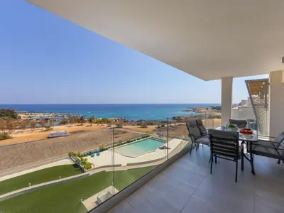 a dining room with a view of the ocean at Emerald Bay Sea-Front Penthouse in Protaras