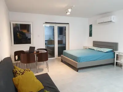 a bedroom with a bed and a desk with a laptop at Studio In the Centre of the city in Ayia Napa