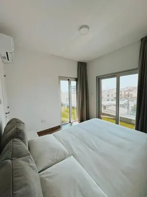 a bedroom with a large white bed and windows at 3 Br Penthouse Jacuzzi Seaview in Limassol