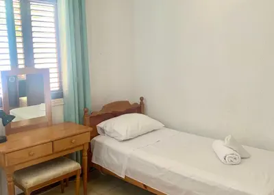 a bedroom with a bed and a desk and a mirror at Sandy Beach Villas Sea View Apartment Pyla in Larnaka