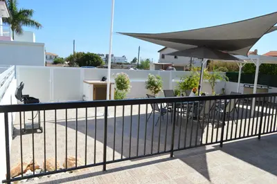 a balcony with a table and an umbrella at Ayia Napa Marina Luxury Villas - Pearl in Ayia Napa