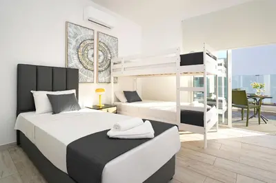 a bedroom with two beds and a bunk bed at Villa Evelin - Ayia Napa Resort Center in Ayia Napa