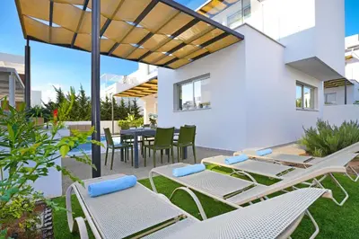 a patio with chairs and tables and a table and chairs at Villa Evelin - Ayia Napa Resort Center in Ayia Napa