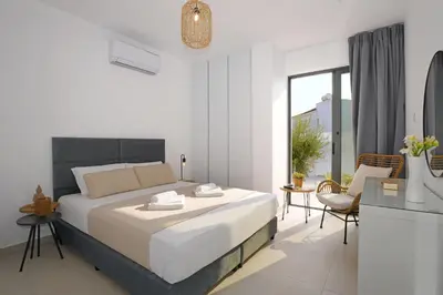 a white bedroom with a large bed and a balcony at Villa Merope - 3Bed All En-suite in Paralimni