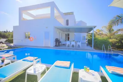 a villa with a swimming pool in front of a house at Akefalou Bay Villa in Protaras