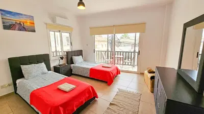 a bedroom with two beds and a flat screen tv at Sky Ward City Rooms, 150m from Chabad Lubavitch in Larnaka