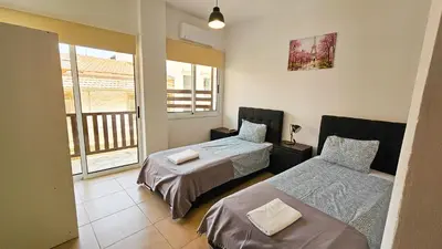 a bedroom with two beds and a balcony at Sky Ward City Rooms, 150m from Chabad Lubavitch in Larnaka