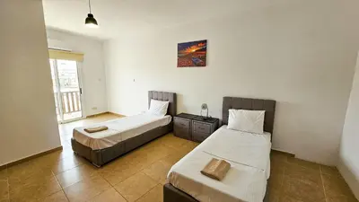 a bedroom with two beds and a window at Sky Ward City Rooms, 150m from Chabad Lubavitch in Larnaka
