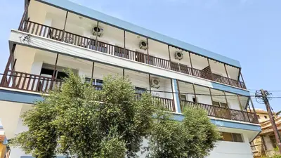 an apartment building with balconies and a tree at Sky Ward City Rooms, 150m from Chabad Lubavitch in Larnaka