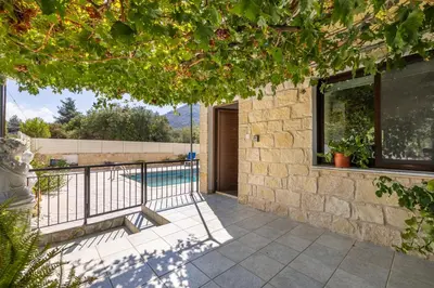 a house with a balcony with a swimming pool at JP Pool House in Trimiklini